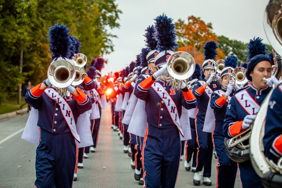 Fighting Illini Marching band playing and marching in the street.