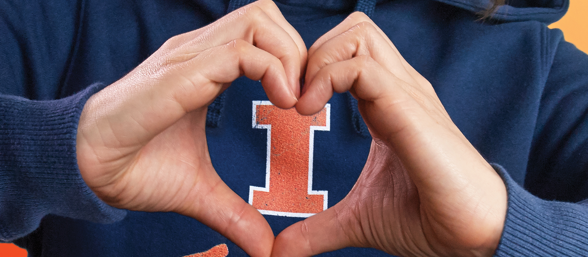 Two hands making a heart shape with an Illini "I" in the space of the heart shape.