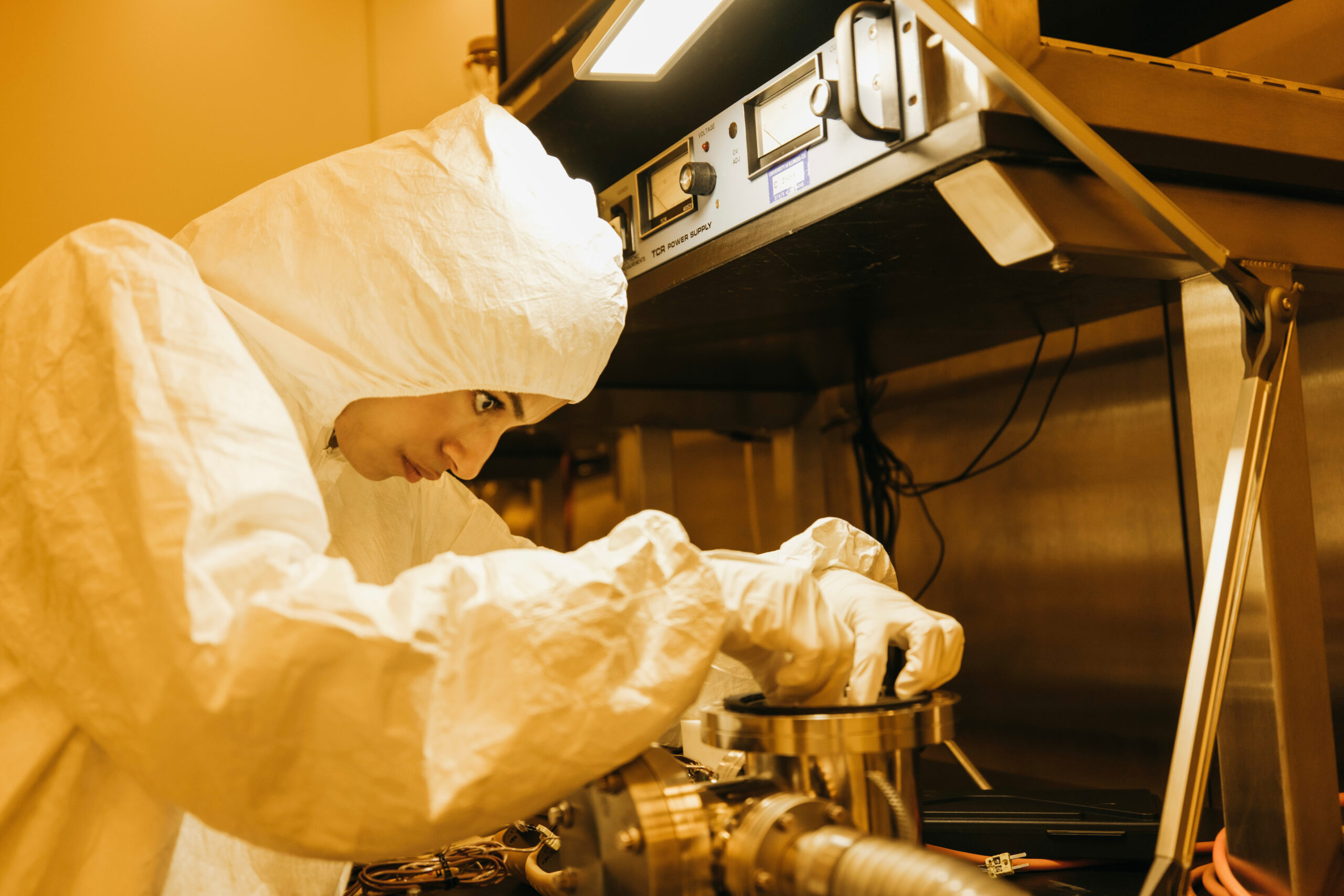 Student in a cleanroom suit working on a project.