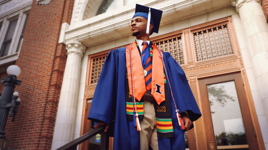 Graduate in cap and gown in front of Lincoln hall.