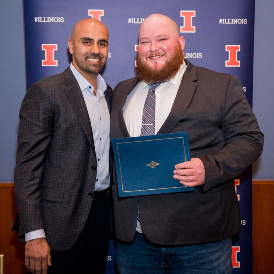 Andrew Askew smiles and stands with his award and professor, Naiman Khan.