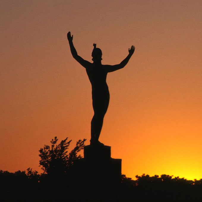 Statue with sunset in the background.