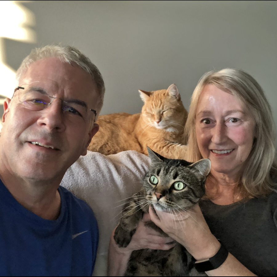 Laurie Wiechert-Sharar and Dave Sharer smiling and posing with their two cats.